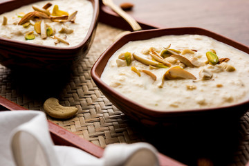 Sweet Rabdi or Lachha Rabri or basundi, made with pure milk garnished with dry fruits. Served in a bowl over moody background. Selective focus