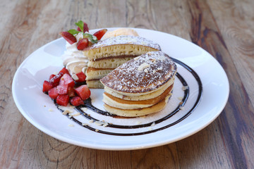 Closeup of Vanilla ice cream with pancake and Strawberry on wooden table