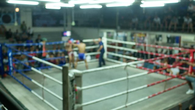 asian men thai boxing are punch and kick together with committee on canvas boxing stadium