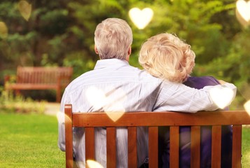 Portrait of happy senior couple in green blurred park background