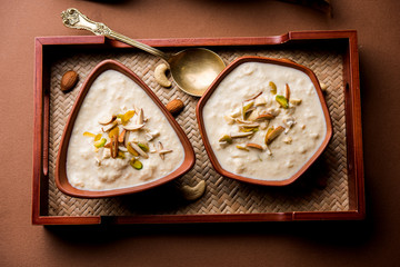 Sweet Rabdi or Lachha Rabri or basundi, made with pure milk garnished with dry fruits. Served in a bowl over moody background. Selective focus