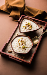 Sweet Rabdi or Lachha Rabri or basundi, made with pure milk garnished with dry fruits. Served in a bowl over moody background. Selective focus
