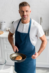 adult man showing thumbs up with steak on pan