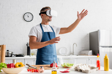 adult cooker in virtual reality headset standing at kitchen