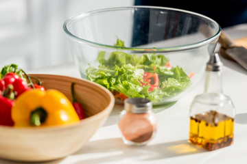 close up view of salad ingredients and spices on kitchen table
