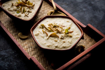 Sweet Rabdi or Lachha Rabri or basundi, made with pure milk garnished with dry fruits. Served in a bowl over moody background. Selective focus
