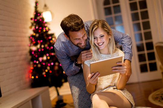 Handsome young couple with tablet at New Years eve