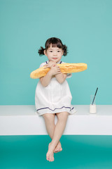 Little pretty Asian girl laughing portrait with milk and bread, healthy and happy lifestyle.