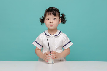 Little pretty Asian girl laughing portrait with milk and bread, healthy and happy lifestyle.
