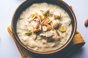 Sweet Rabdi or Lachha Rabri or basundi, made with pure milk garnished with dry fruits. Served in a bowl over moody background. Selective focus