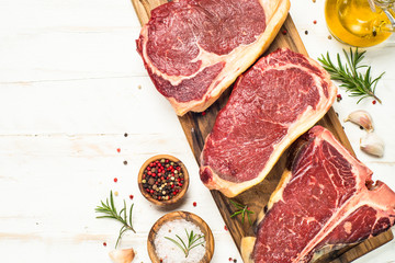 Raw meat beef steak on white top view.