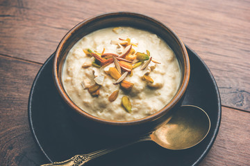 Sweet Rabdi or Lachha Rabri or basundi, made with pure milk garnished with dry fruits. Served in a bowl over moody background. Selective focus
