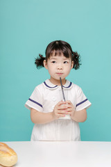 Little pretty Asian girl laughing portrait with milk and bread, healthy and happy lifestyle.