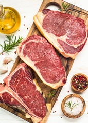 Raw meat beef steak on white top view.