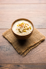 Sweet Rabdi or Lachha Rabri or basundi, made with pure milk garnished with dry fruits. Served in a bowl over moody background. Selective focus