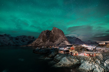 Fisherman village with Aurora in the background travel concept world explore northern light / Lofoten Norway