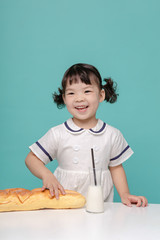 Little pretty Asian girl laughing portrait with milk and bread, healthy and happy lifestyle.