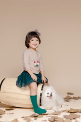 Little pretty Asian girl sitting in an autumn background.