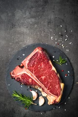 Photo sur Plexiglas Steakhouse T-bone beef steak on black with spices.