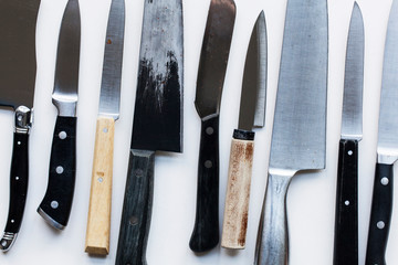 A variety of knives on a plain background. Knife crime concept