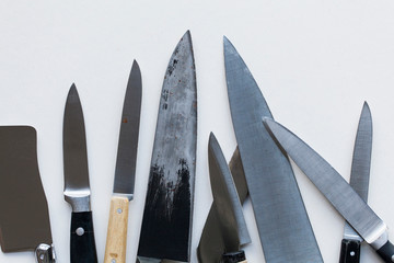 A variety of knives on a plain background. Knife crime concept