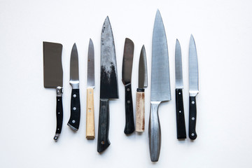 A variety of knives on a plain background. Knife crime concept