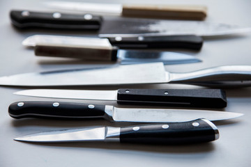 A variety of knives on a plain background. Knife crime concept