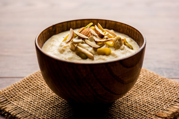 Sweet Rabdi or Lachha Rabri or basundi, made with pure milk garnished with dry fruits. Served in a bowl over moody background. Selective focus