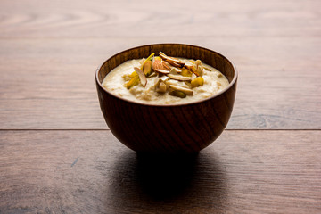 Sweet Rabdi or Lachha Rabri or basundi, made with pure milk garnished with dry fruits. Served in a bowl over moody background. Selective focus