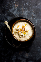 Sweet Rabdi or Lachha Rabri or basundi, made with pure milk garnished with dry fruits. Served in a bowl over moody background. Selective focus
