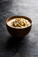 Sweet Rabdi or Lachha Rabri or basundi, made with pure milk garnished with dry fruits. Served in a bowl over moody background. Selective focus