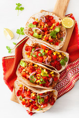 mexican beef and pork tacos with salsa, guacamole and vegetables