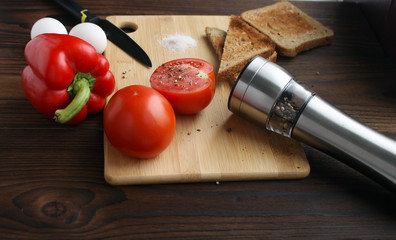 Bulgarian pepper, tomato, eggs and bread on the table.