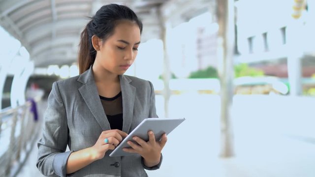 Young working woman standing and use tablet at outdoor
