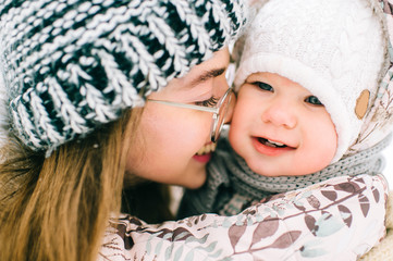 Lifestyle portrait of young beautiful mother playing with her little daughter in winter. Happiness...