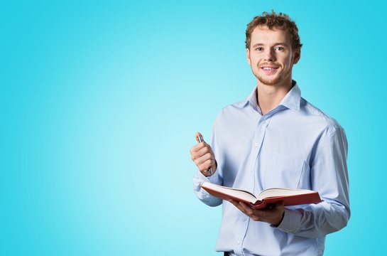 Young male teacher   standing with book