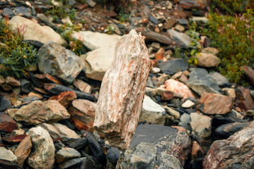 light natural cobblestone stands vertically in delicate balance on another stone