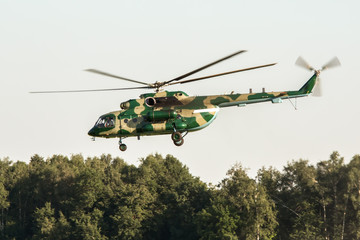 The military helicopter in camouflage taking off