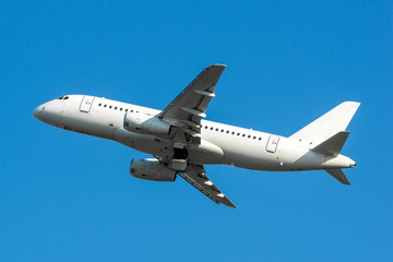Modern white civilian airplane in the blue sky