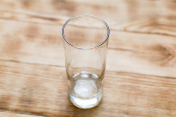 An empty glass on a wooden background.