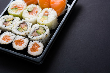 Japanese food: maki and nigiri sushi set on black background. Copyspace