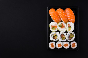 Japanese food: maki and nigiri sushi set on black background. Flat lay top-down composition. Copyspace