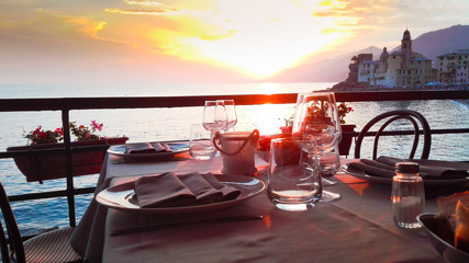 Prepared table with a spectacular sunset on the Genoa coast