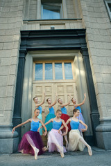 Fototapeta na wymiar Ballet dancers dancing on street. Young ballerinas in color tutus. Ballet feet on the point