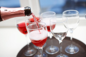 Rose champagne in wineglasses. Champagne is poured into glasses