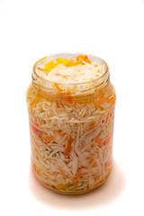 Preserved cabbage and red paprika salad in glass jar on a white background