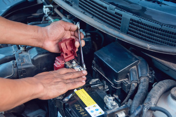 Car mechanic working Install battery with wrench in garage. Repair service.