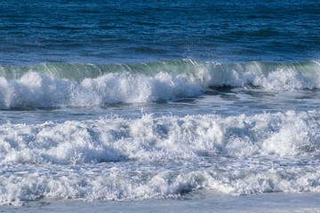 Fototapeta premium sea ​​waves breaking on the shore of the beach splashing and forming foam