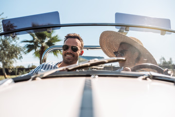 Multiracial couple in a convertible vintage car