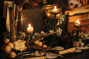 Black candle Magic Ritual. Antique Magic Book. Witchcraft  Peacock feathers and candle background.